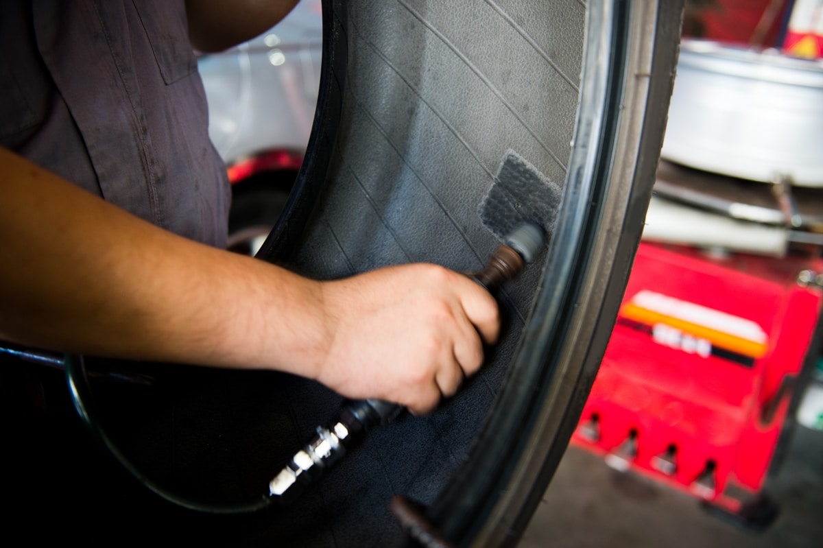 A Car Tire Being Patched By A Mechanic